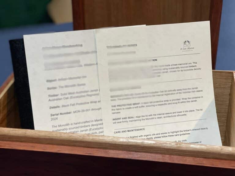 Handcrafted Monolith Jarrah Urn - Western Australian Solid Timber Memorial Vessel showing care card and certificate of authenticity.